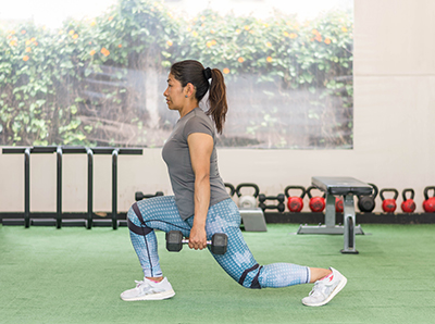 Woman doing a lunge holding weights
