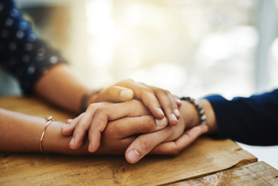 Hand holding and comforting another hand