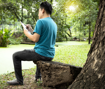 A man drawing in the park