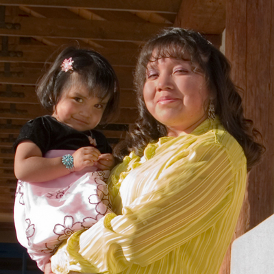 A woman carrying a toddler girl