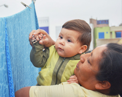 Interracial mom and son hanging a blanket