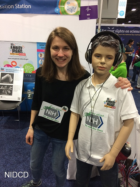 Woman with her arm around a child mannequin with headphones