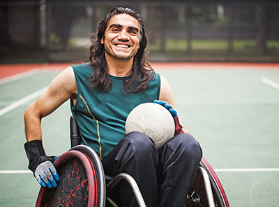 Man in wheelchair holding a volleyball